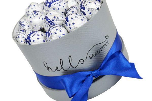 bacio je primerno darilo za moškega in je v sivi škatli z modro pentljo in čokoladicami bacio