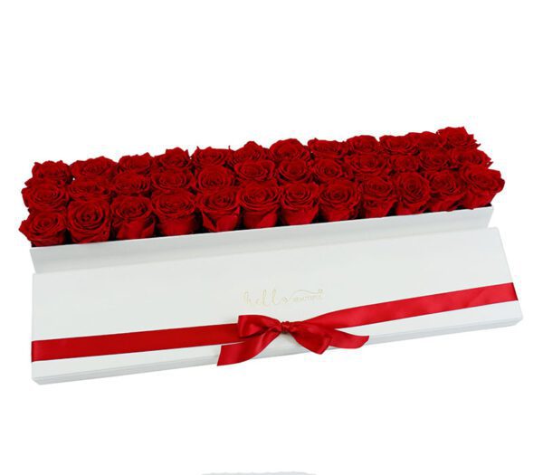 red roses in a rectangular long white box with red bow