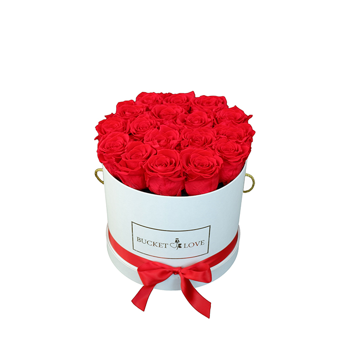 Gold lettering on a white jug with red roses against a white background